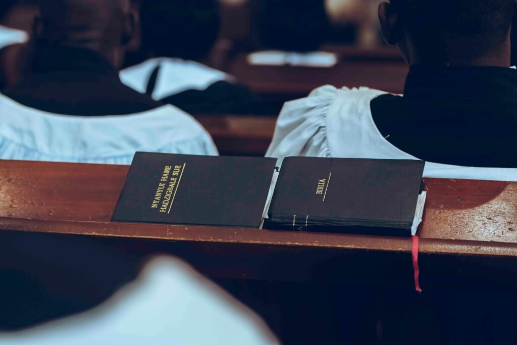 Hymn book and Bible placed on church pew during a service.